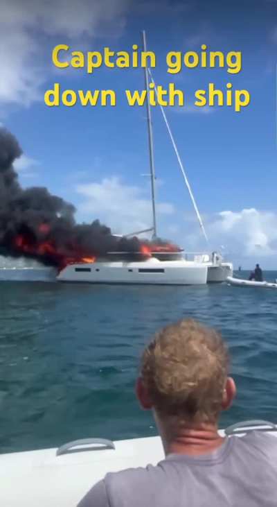 Man tries to save boat engulfed in flames.
