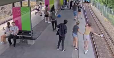 Insane woman pushes elderly man onto the train tracks