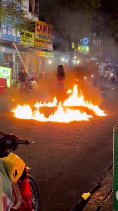Lighting fire in middle of a busy road.