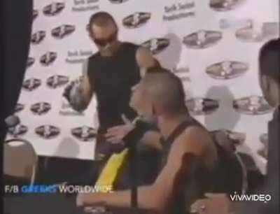 Fighter throws water and starts fight with opponent at press conference then gets knock into another world in the ring.