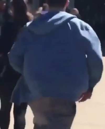 Pretending to hide a gun while walking into a school