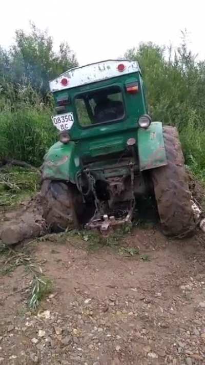 Using tree limbs chained to the wheels to free a stuck tractor