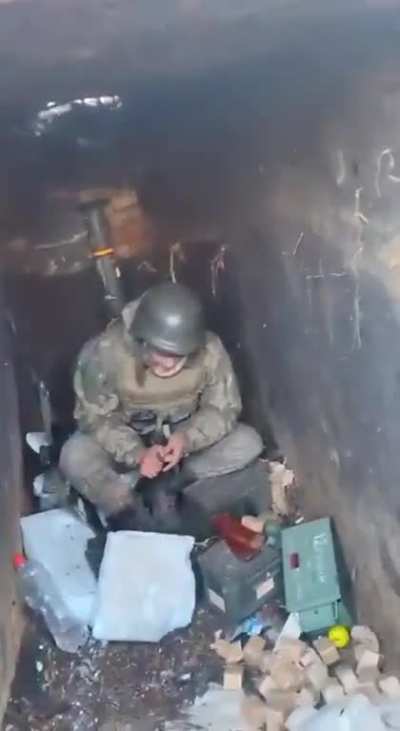 UA POV Ukrainian fighters are in a trench, while a Russian tank burns close to them
