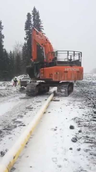 This dude hops his escavator over a pipeline.