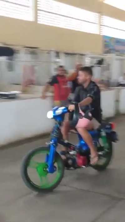 Man with motorized bike at market takes a tumble