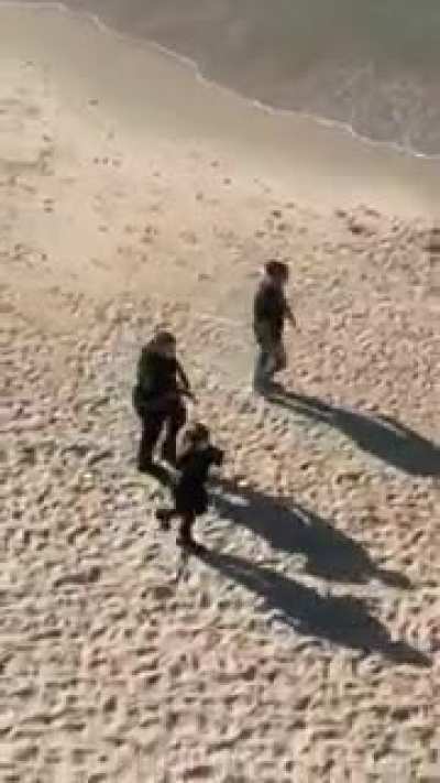 Beach goers running away from police in quarantined Tel Aviv this week