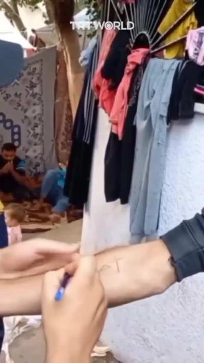 Kids writing their names on their hands and arms to be identified