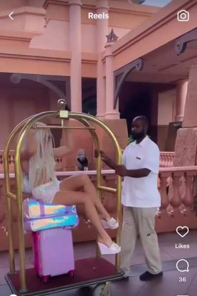 The workers look so annoyed. The one guy even shakes his head &ldquo;no&rdquo; when she&rsquo;s on the luggage cart