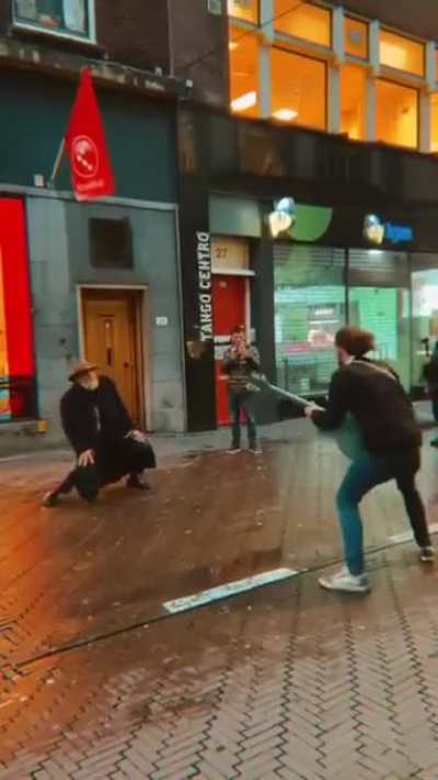 An old man dancing to a street musician