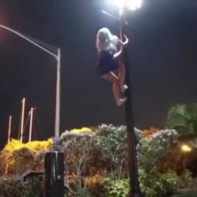 Woman uses a lamp post for a quick workout