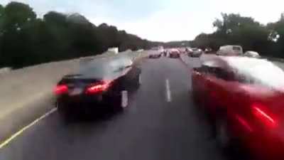 Bikes pass between cars in traffic