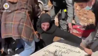 Israeli police attack a Palestinian woman trying to protect her son's grave from being dug out by the Israeli government to build a park