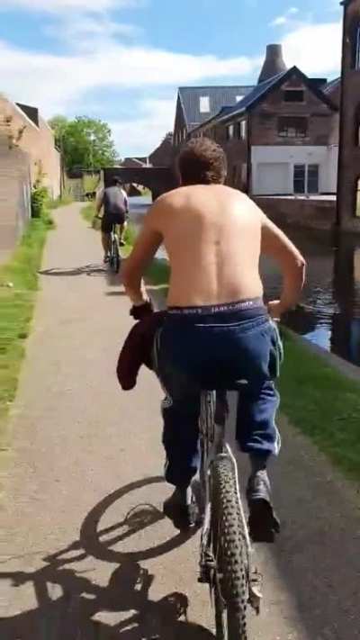 Guy pushes random cyclist into river