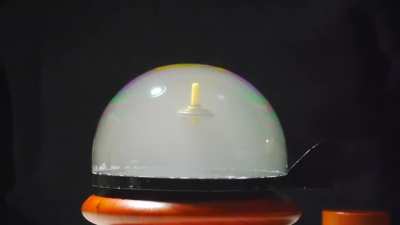 Magnetic spinning levitron inside a bubble