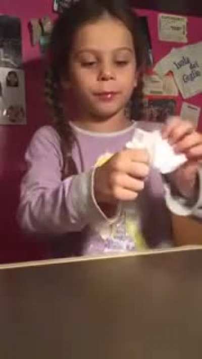 The little girl shows trick with the disappearance of the napkin.