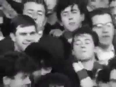 Liverpool supporters sing "she loves you" by The Beatles on the Kop in 1964