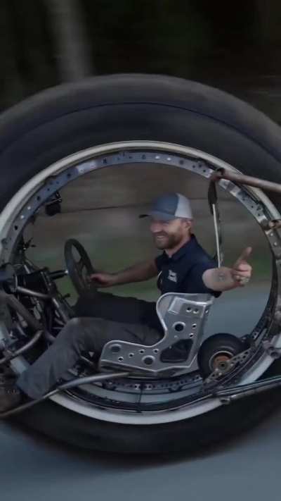 Guy built a 3-wheeled vehicle that he drives from inside the massive front wheel