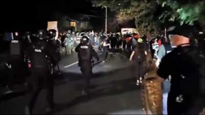 Police slam protester to ground from behind while Paul Robeson's "John Brown's Body" plays in the background.