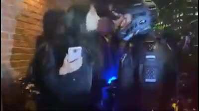 Protestor spits in the face of a police officer