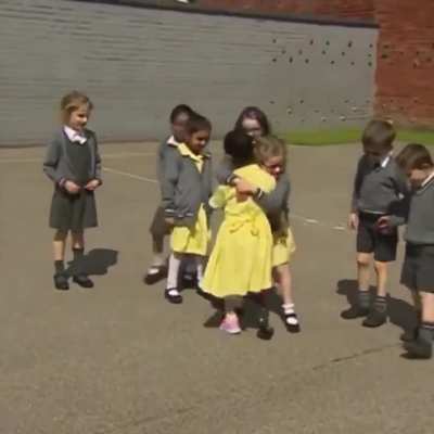 Little girl showing her prosthetic leg to her classmates at school