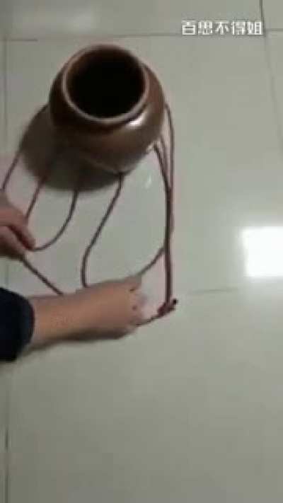 Using a single piece of string to securely carry a pot