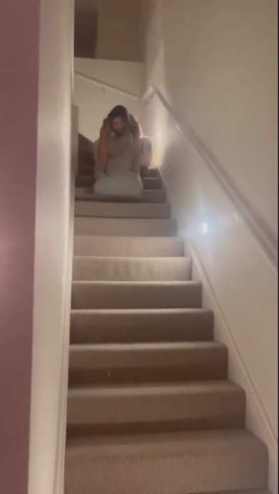 Trying to ride a cushion down a staircase