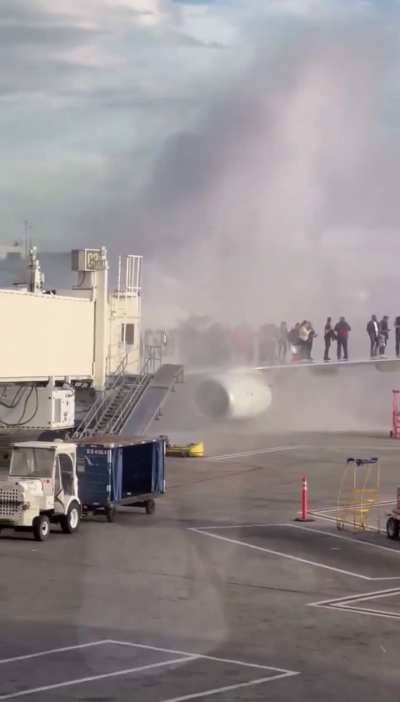 Passengers evacuating from American Airlines flight 4012 which caught fire at Denver airport