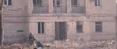 Russian soldiers take casualty in a street and struggle to move his body in Mariupol. 2022