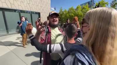 Man attends an anti-Dave Chappelle Netflix protest with a sign that says, "we like Dave" and "jokes are funny." Crowd was unimpressed, broke the man's sign and got in his space.