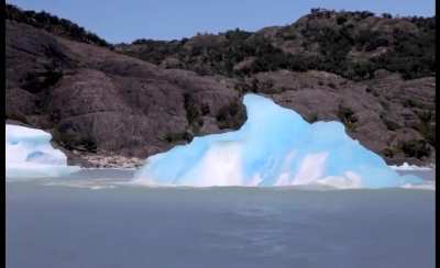 Iceberg flip over to reveal glowing underwater face