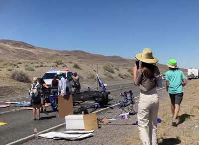 Police ram into climate protestor's road blockade, almost hitting them, before turning back and drawing weapons and making arrests. Video shot in Nevada, United States.