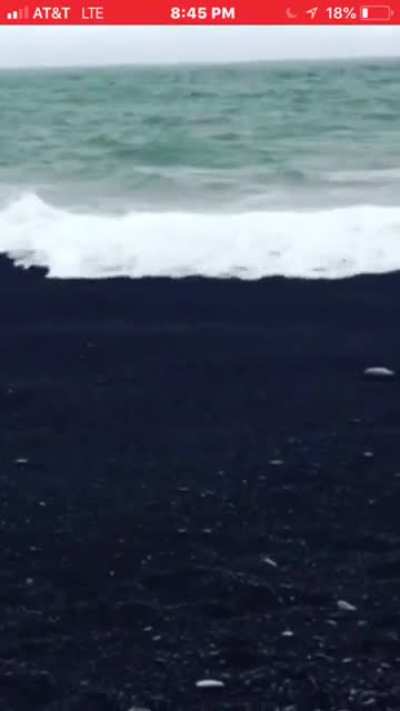 Water disappearing in coarse black sand