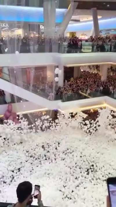 Huge net of balloons being opened over the crowd