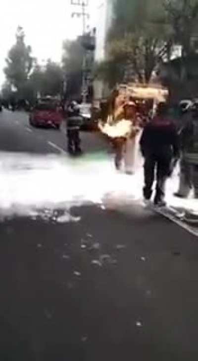 Firefighter carries a gas tank out of a restaurant in Mexico city.