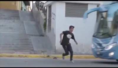 Guy tries grinding on his skateboard down the wall of a stairwell. The stairwell is right next to the road. I hope the bus is ok.