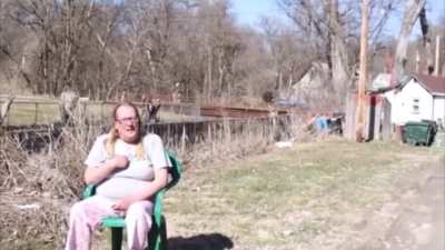 A miserable person drags over a lawn chair to yell at some people who were cleaning up trash and recording a video