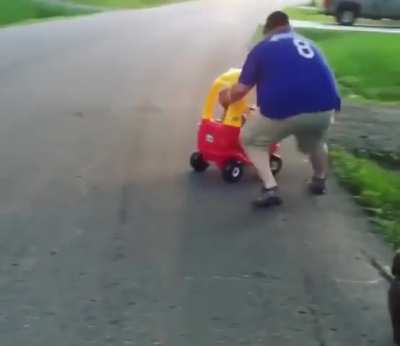 Dad shows kid how to keep the car on the road.