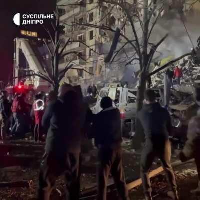 People are assisting emergency services near the destroyed apartment building in Dnipro by clearing debris, protecting the territory, and helping residents. Source: Suspilne Dnipro
