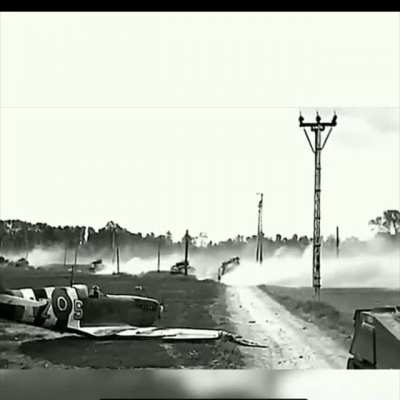 British armor passing a downed Canadian fighter in France