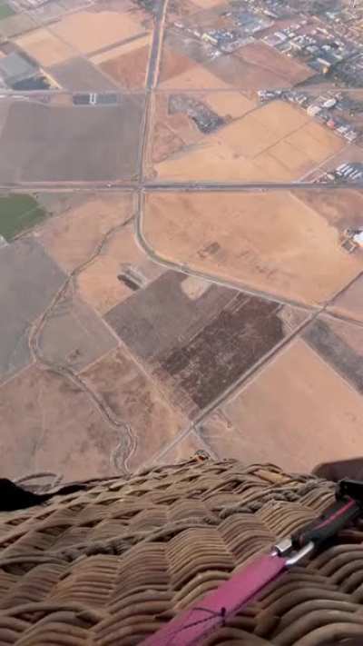 Skydiver Josh Neuman swings from a hot air balloon to start his jump.