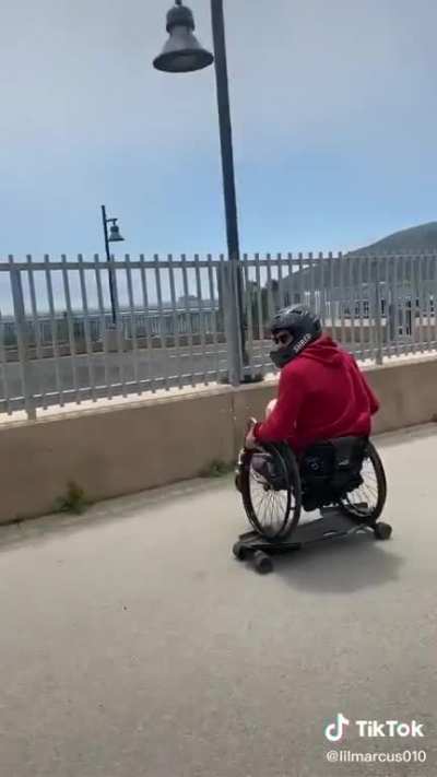 Um cara de cadeira de rodas andando de skate