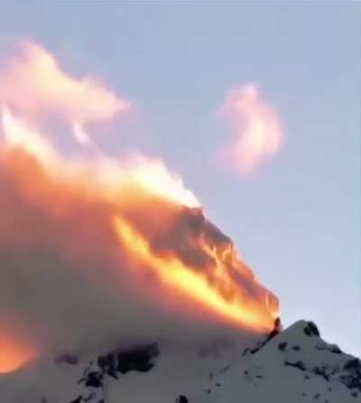 This mountain in China looks like it’s burning , because the sun hits it at a perfect angle and the clouds are constantly moving.

It is a phenomenon called alpine glow.