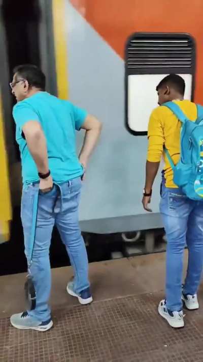 Indian man with a dog tries to board a moving train, potentially killing the dog