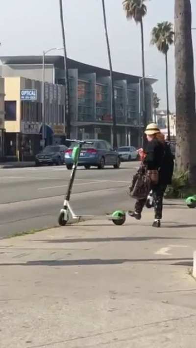 Lady knocks down e-bikes & scooter for no reason