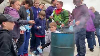 Parents teach their children to burn masks
