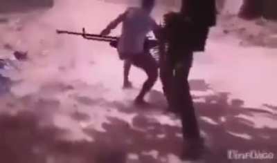 Sudanese soldiers firing a heavy machinegun on foot at the RSF