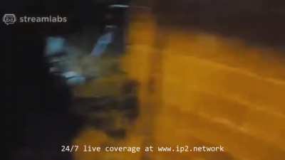 A Muslim man and his pregnant wife look on as looters steal from their phone store.