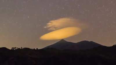 Lenticular cloud stays over the mountain for several hours.