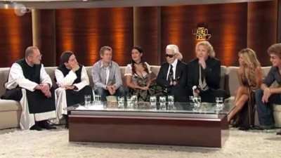 Salma had to be convinced to wear this outfit. Karl Lagerfeld (the guy wearing glasses) convinced her. She was breastfeeding and didn&rsquo;t want to wear a corset. Immediately the host speaks in German to say a sexual innuendo about her that she doesn&rsquo;t unders
