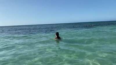 Wading in the ocean. That ass keeps her afloat.
